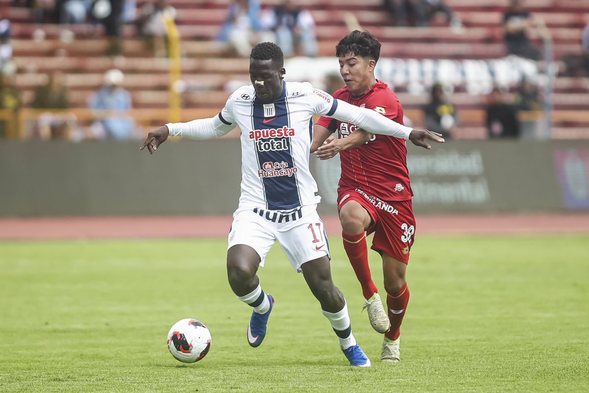 Edu Villar, de Sport Huancayo, disputa el bal&oacute;n con un jugador de Alianza Lima en el estadio IPD de Huancayo