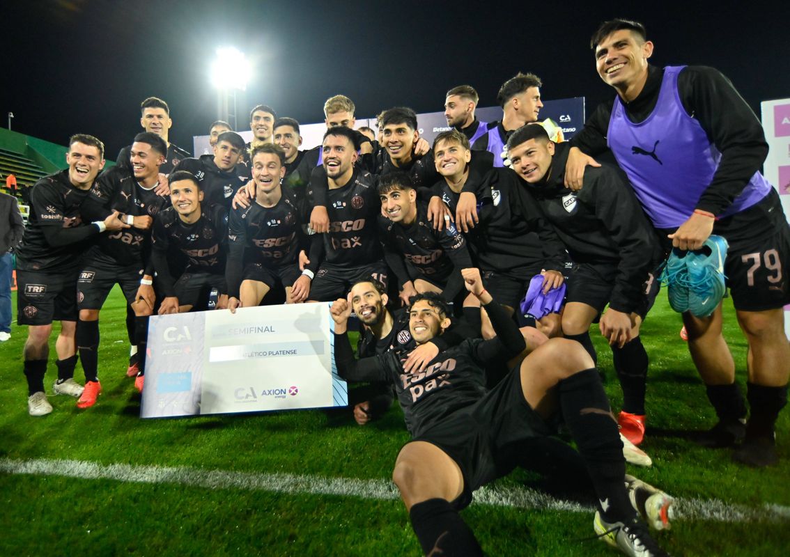 Jugadores de Platense posan con el cheque de clasificaci&oacute;n tras vencer a Estudiantes en los cuartos de final de la Copa Argentina