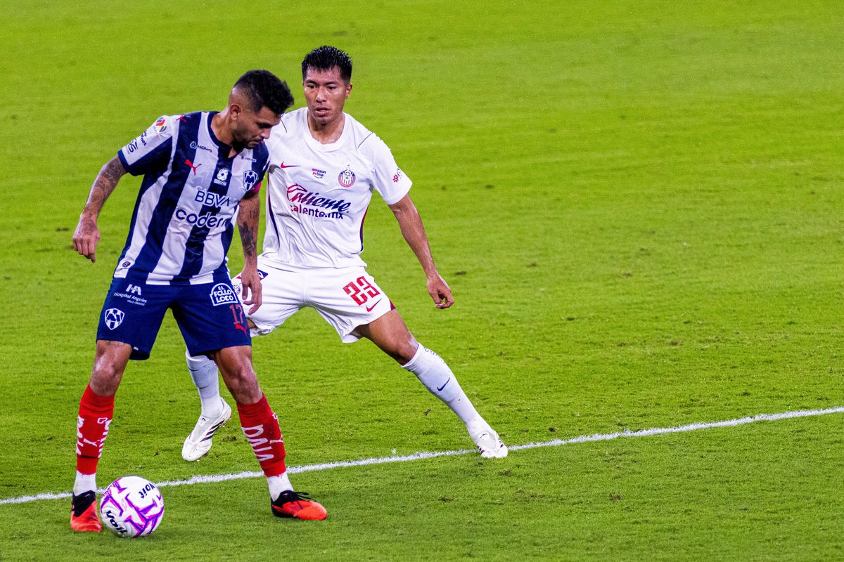 Un jugador de Monterrey protege el bal&oacute;n ante un rival de Guadalajara en el partido del Apertura 2026